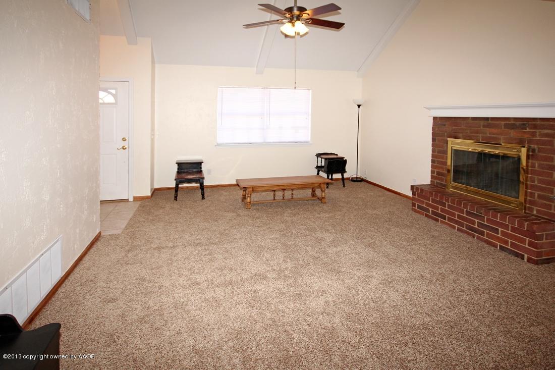 5216 Leland Drive Amarillo, TX 79110 - Photo 5 of 23 a view of room with a ceiling fan and a fireplace