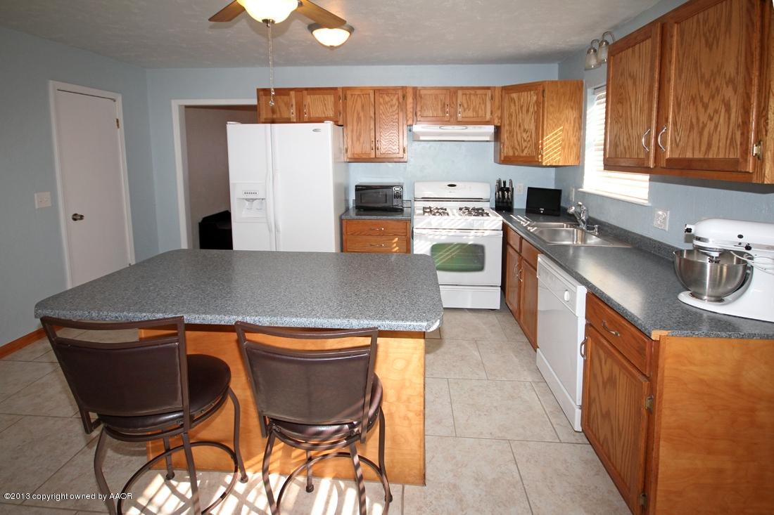 5216 Leland Drive Amarillo, TX 79110 - Photo 6 of 23 a kitchen with a stove a refrigerator and a sink