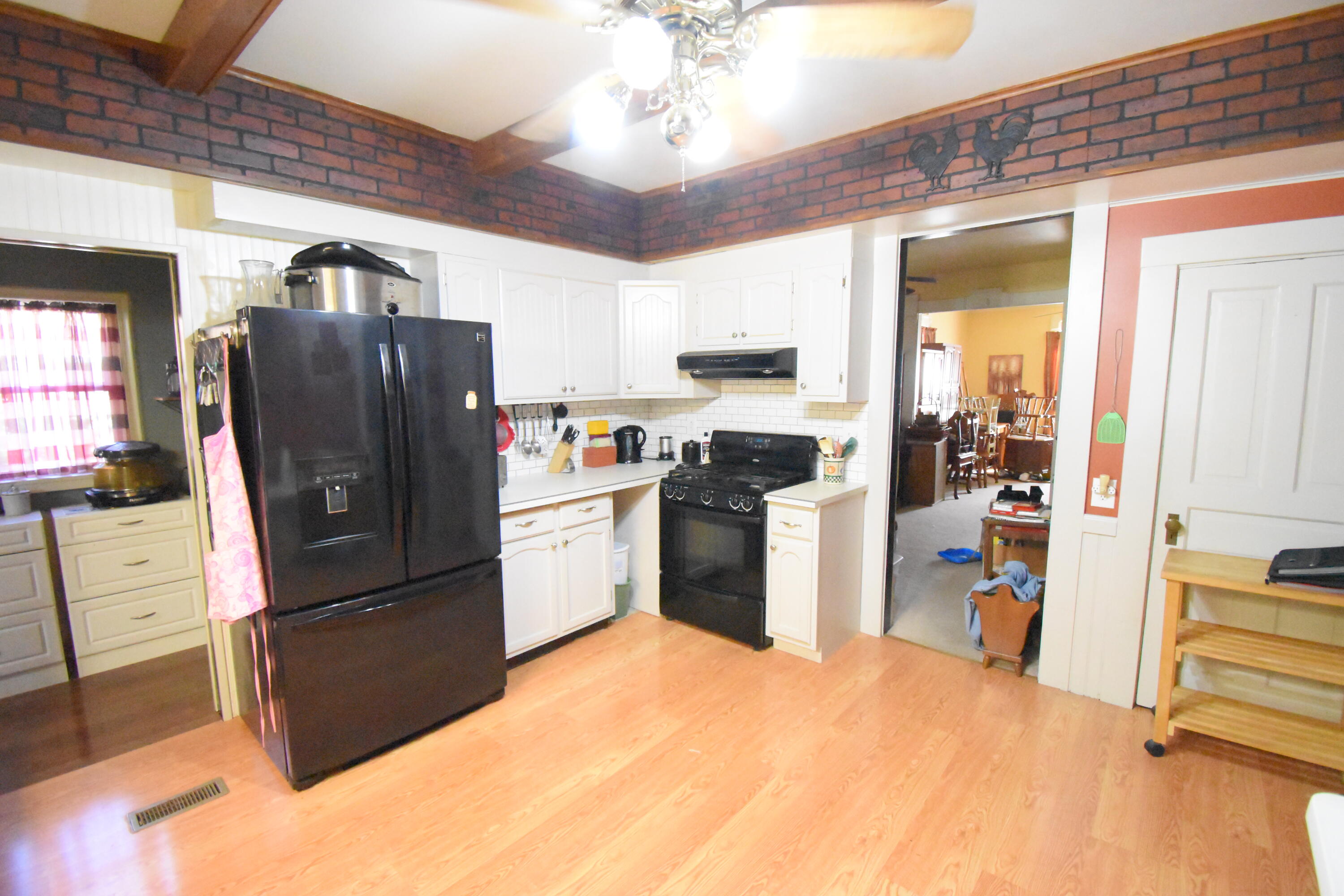 522 North Cullen Street Rensselaer, IN 47978 - Photo 11 of 43 a kitchen with stainless steel appliances a refrigerator a stove a sink a dining table and chairs with wooden floor