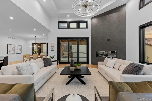 a living room with furniture kitchen view and a chandelier
