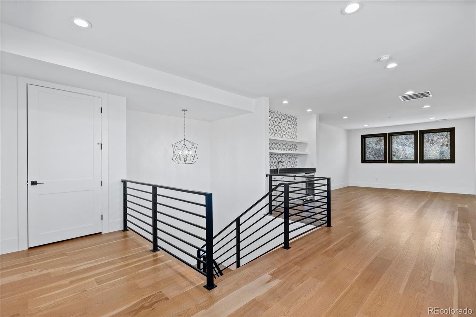 8103 Raphael Lane Littleton, CO 80125 - Photo 22 of 31 a view of a livingroom with wooden floor and a ceiling fan