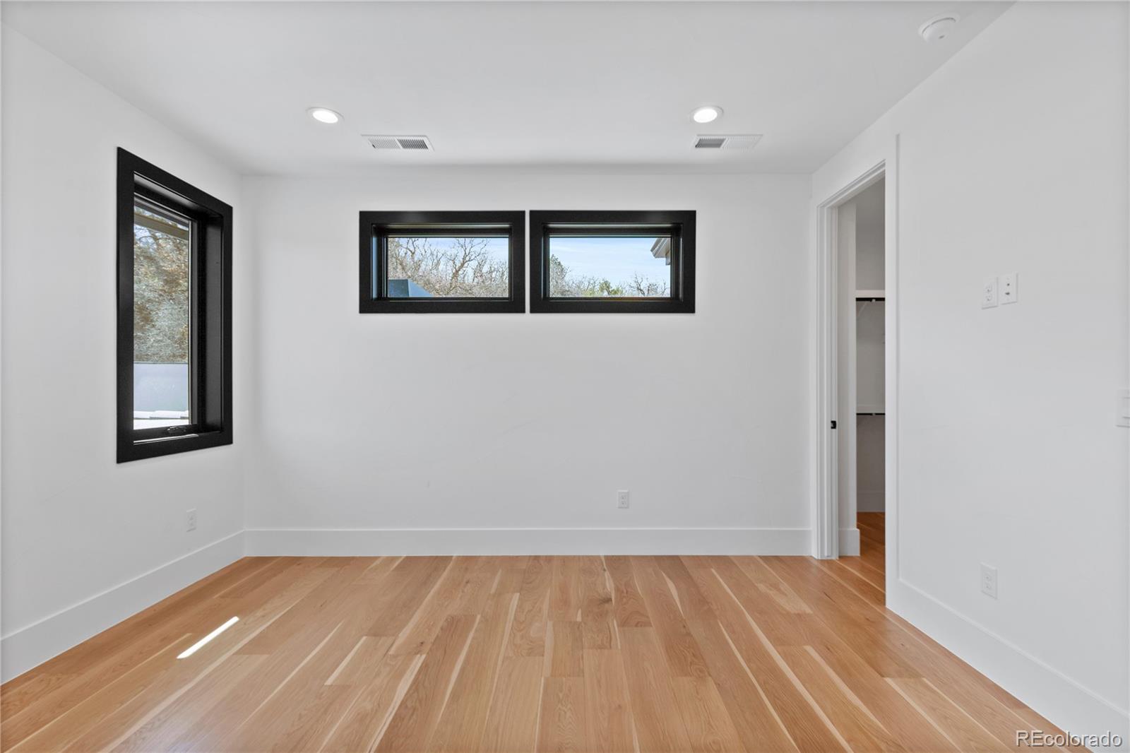 8103 Raphael Lane Littleton, CO 80125 - Photo 23 of 31 a view of an empty room with wooden floor and a window