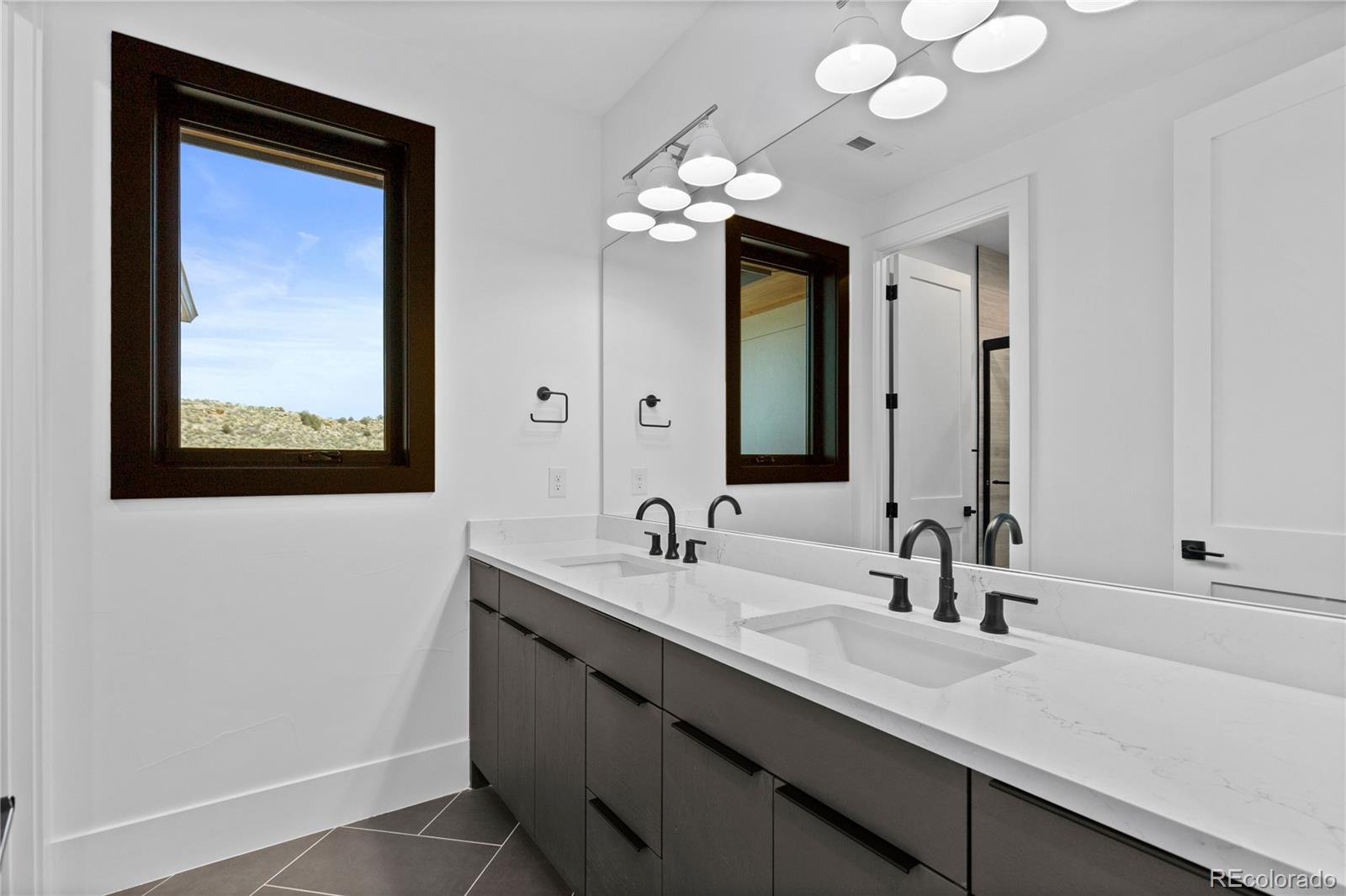 8103 Raphael Lane Littleton, CO 80125 - Photo 24 of 31 a bathroom with a double vanity sink and a mirror