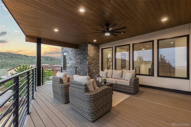 a living room with furniture large windows and wooden floor