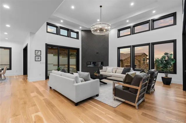 a living room with stainless steel appliances kitchen island a table and a sink