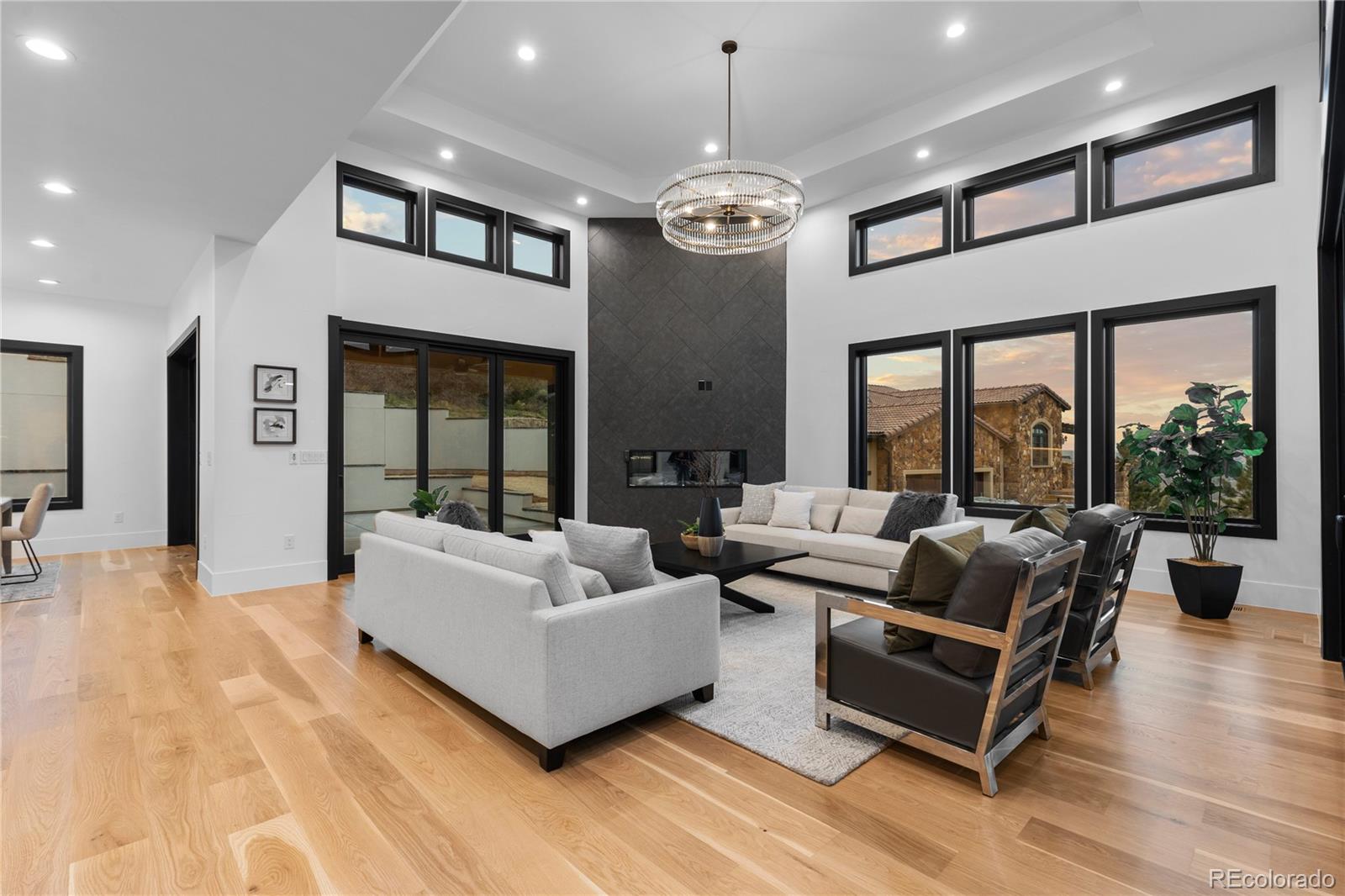 8103 Raphael Lane Littleton, CO 80125 - Photo 7 of 31 a living room with furniture a large window and a chandelier