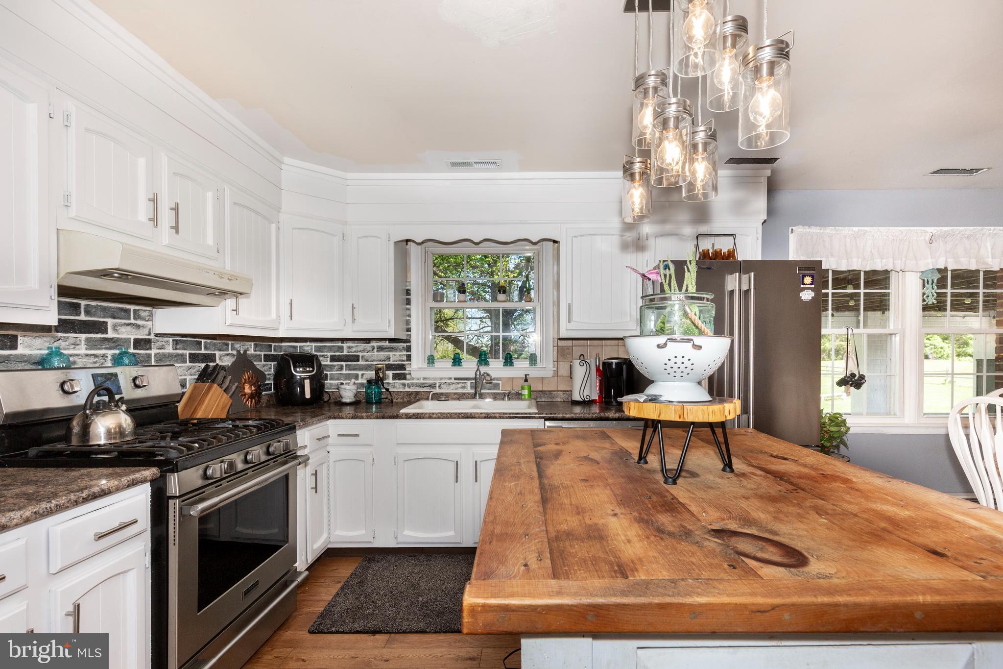 2226 Harney Road Littlestown, PA 17340 - Photo 27 of 113 a kitchen with stainless steel appliances granite countertop a stove a sink dishwasher a refrigerator and white cabinets with wooden floor