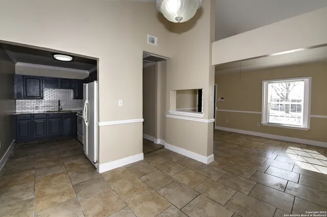 a kitchen with granite countertop a refrigerator and a stove top oven