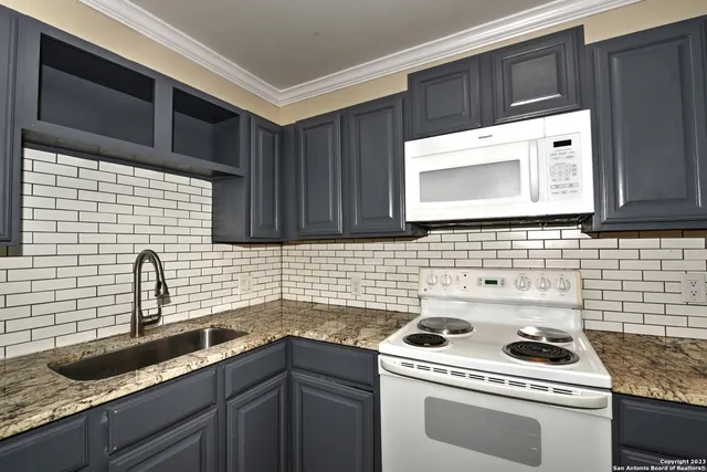a kitchen with a sink stove and cabinets