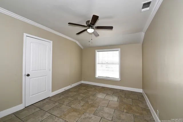 a view of an empty room and window ceiling fan