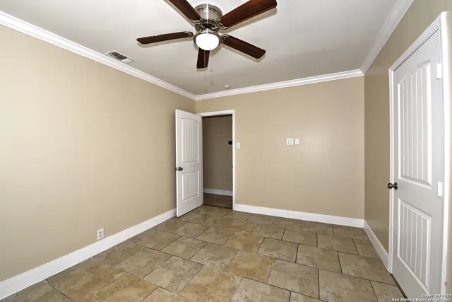 an empty room with closet and a chandelier fan