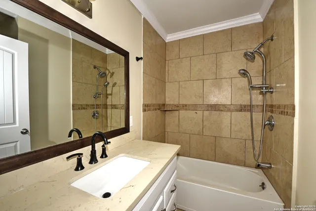 a bathroom with a tub sink and mirror