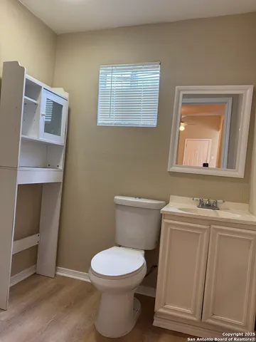 a bathroom with a toilet a sink a vanity and mirror