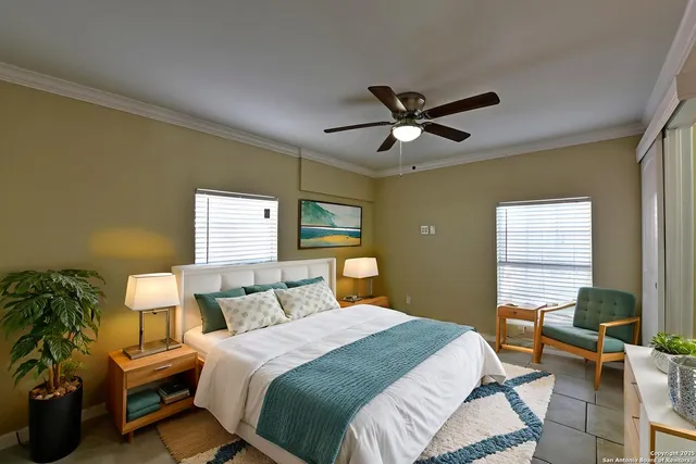 a bedroom with a bed a couch and potted plant with the dresser