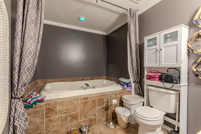 a bathroom with a granite countertop toilet sink and mirror