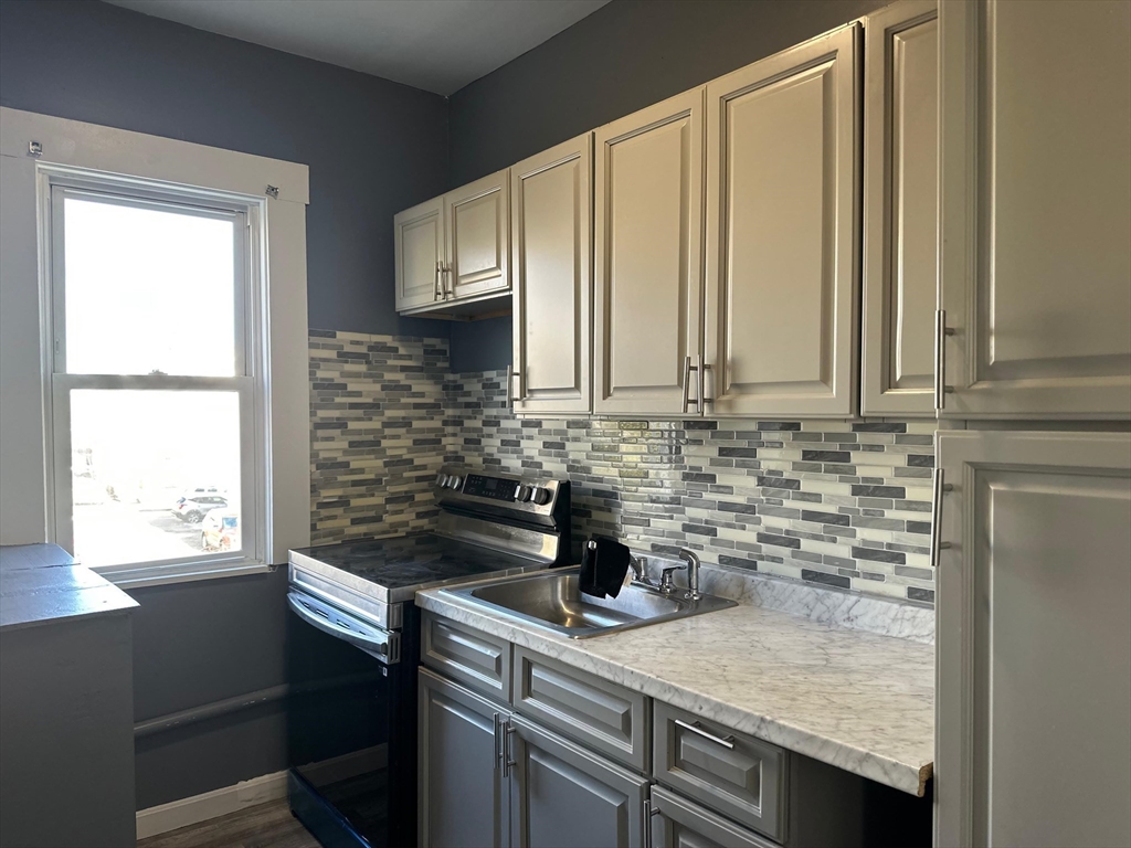 175 Phillips Avenue, Unit 2 New Bedford, MA 02746 - Photo 1 of 4 a kitchen with stainless steel appliances a sink a stove and a window