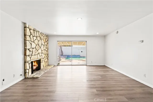 a view of an empty room with a fireplace and a window