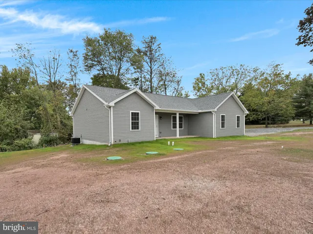 a view of house with outdoor space and trees in the background