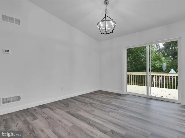 a view of a room with wooden floor and window