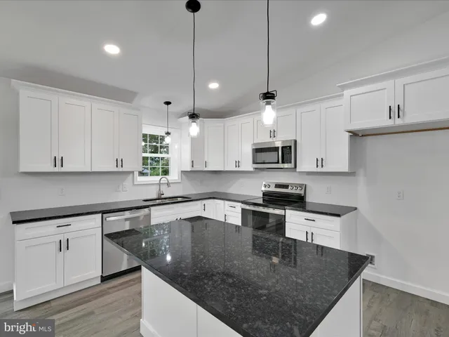 a kitchen with stainless steel appliances granite countertop a sink a stove and center island