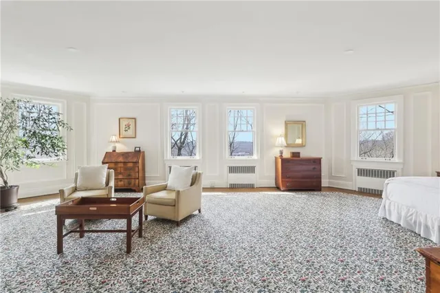 a living room with furniture large window and wooden floor