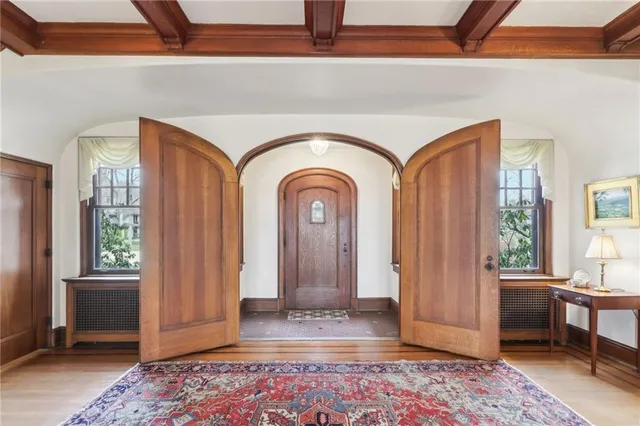 a view of front door with entryway and wooden floor