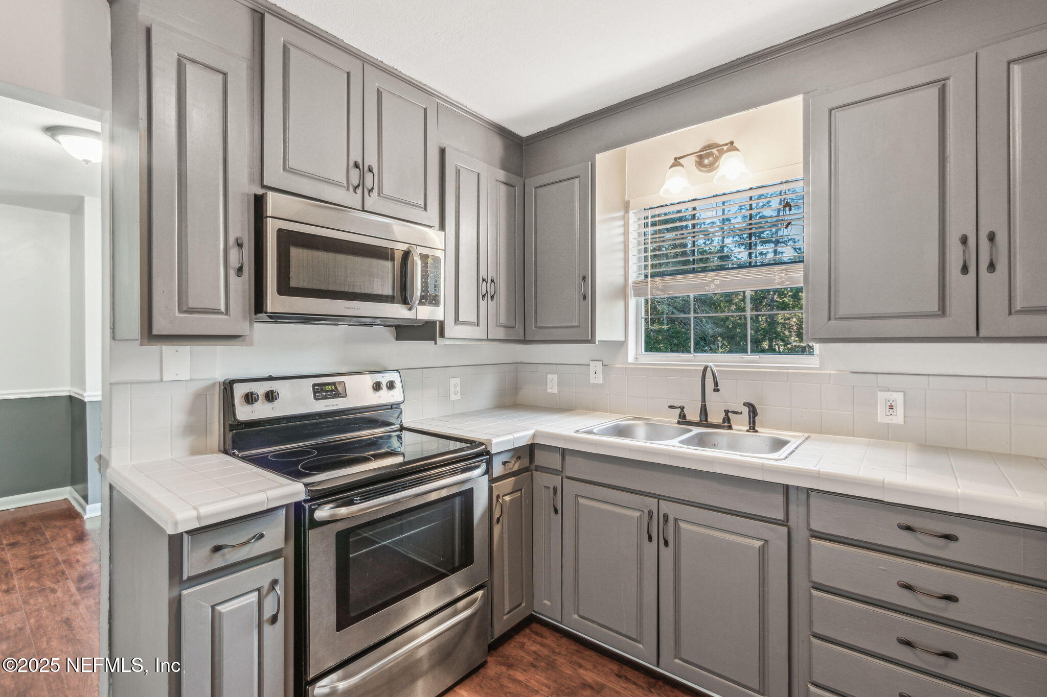 86221 Spring Meadow Avenue Yulee, FL 32097 - Photo 10 of 23 a kitchen with cabinets stainless steel appliances a sink and a window