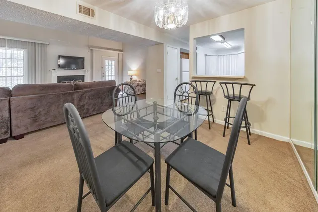 a view of a dining room with furniture and chandelier