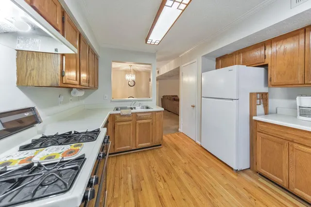 a kitchen with a refrigerator wooden floor and stove