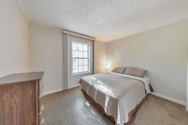 a bed sitting in a bedroom next to a window