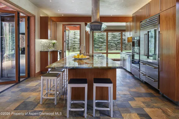 a dining room with stainless steel appliances granite countertop a stove and a refrigerator