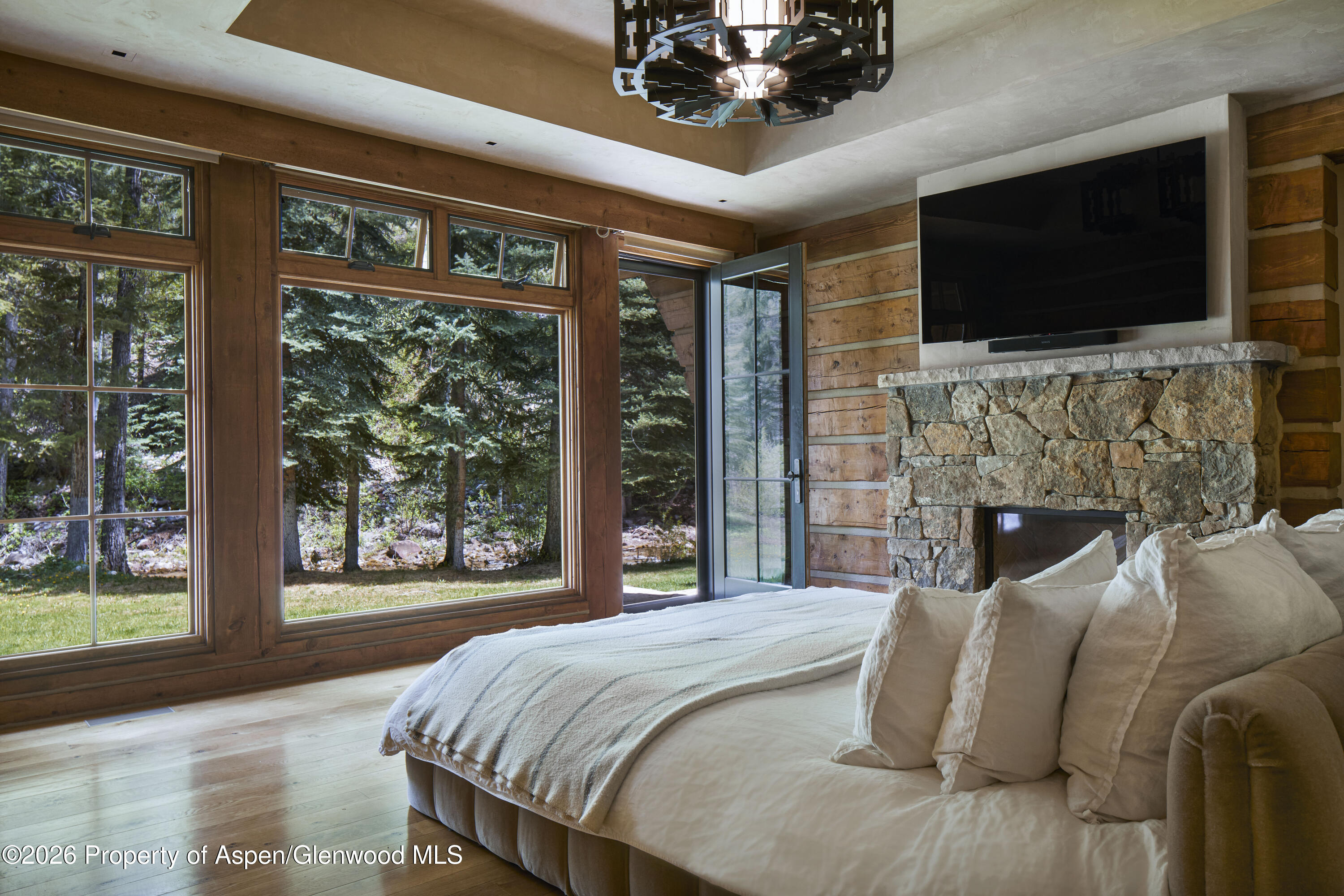 143 Conundrum Creek Road Aspen, CO 81611 - Photo 9 of 16 a bedroom with bed tv and a large window