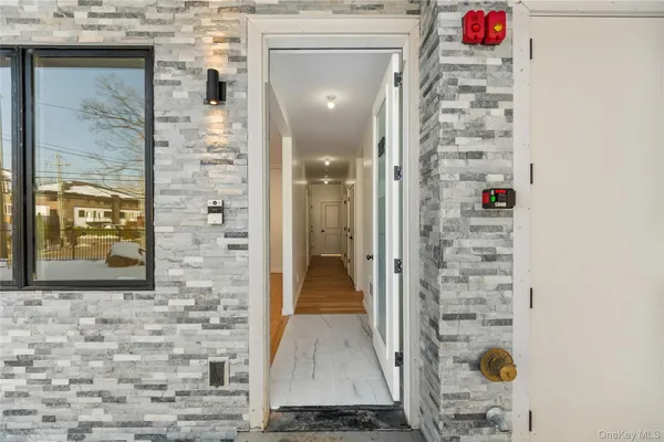 a view of a hallway with wooden floor and a bathroom