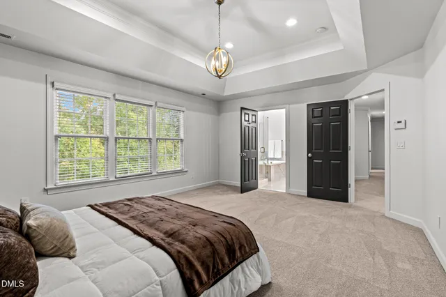 a bedroom with a large bed and a chandelier
