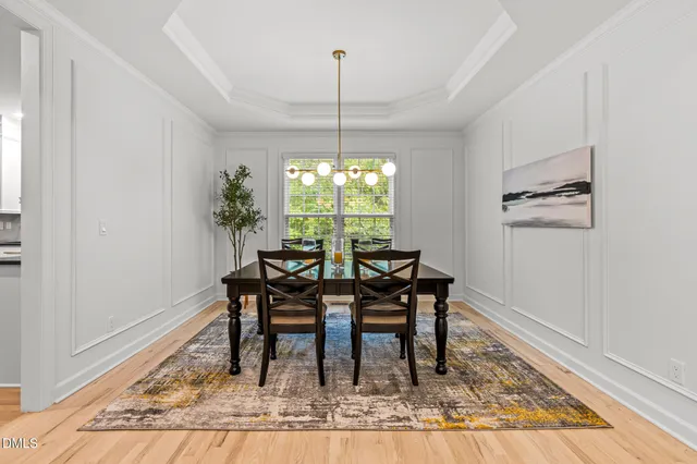 a dining room with furniture a rug and a chandelier