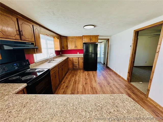 a kitchen with a stove a refrigerator and a sink