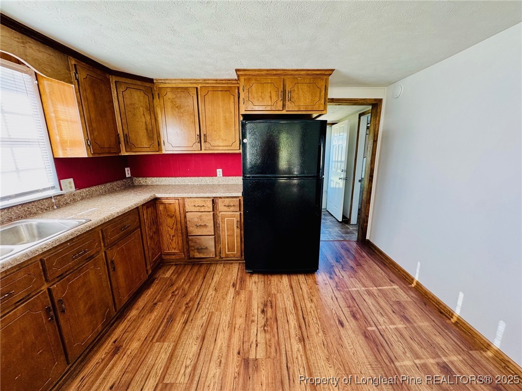 790 Old Whiteville Road Lumberton, NC 28358 - Photo 9 of 29 a kitchen with wooden floors a refrigerator and window