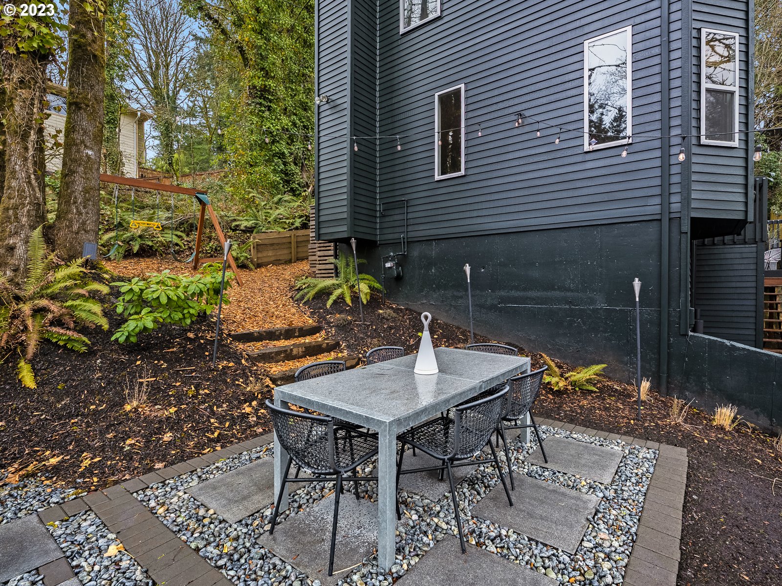 5928 Southwest Yamhill Street Portland, OR 97221 - Photo 20 of 25 a backyard of a house with table and chairs