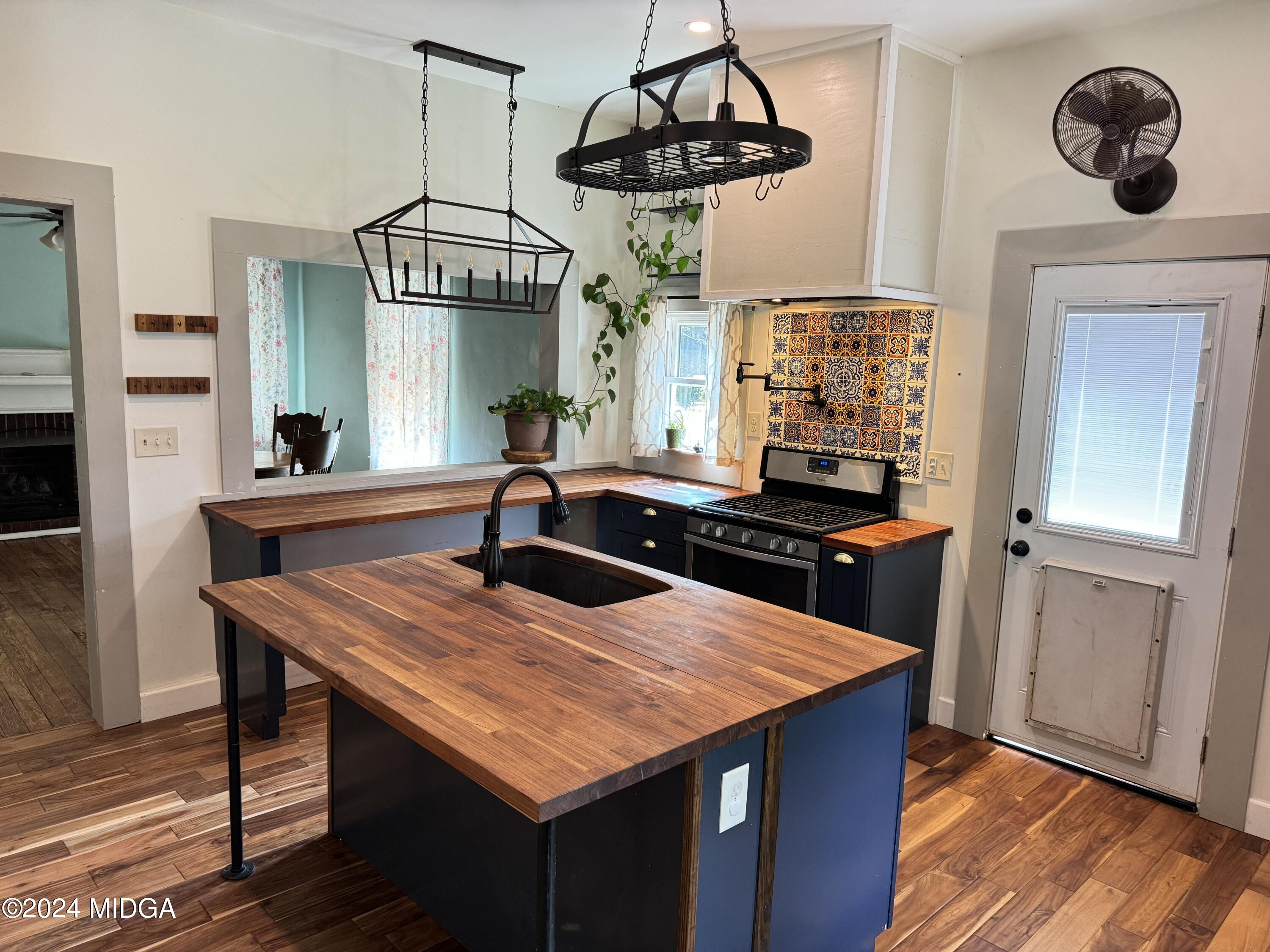 910 Laurel Avenue Macon, GA 31211 - Photo 8 of 41 a kitchen with a table a chandelier and wooden floor