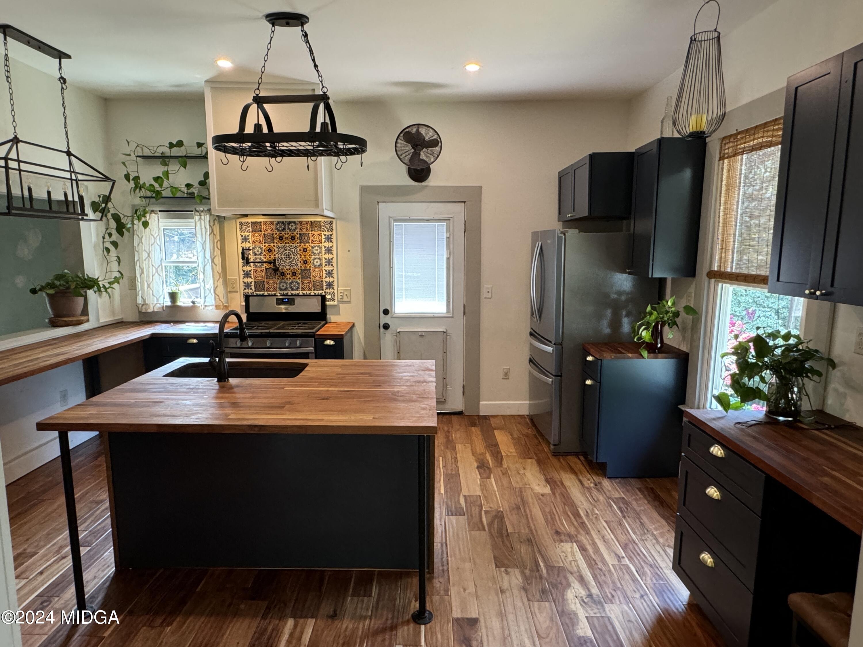 910 Laurel Avenue Macon, GA 31211 - Photo 10 of 41 a kitchen with kitchen island a counter space a sink appliances and cabinets