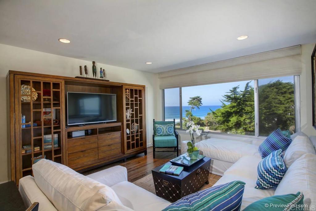 155 15th Street, Unit 19 Del Mar, CA 92014 - Photo 6 of 29 a living room with furniture a bookshelf and a flat screen tv