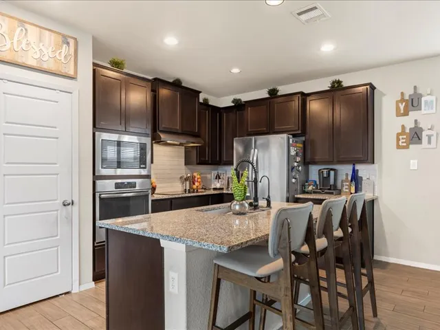 a kitchen with granite countertop stainless steel appliances cabinets a counter space and a sink