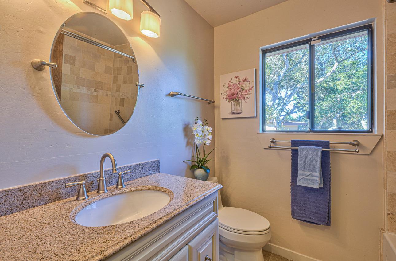 8640 Coker Road Salinas, CA 93907 - Photo 29 of 50 a bathroom with a granite countertop toilet a sink and a mirror