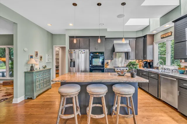 a dining hall with stainless steel appliances granite countertop sink stove and dining table