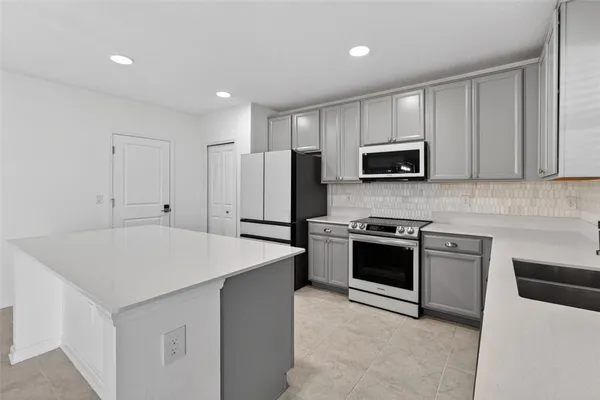 a kitchen with stainless steel appliances a stove sink microwave and refrigerator