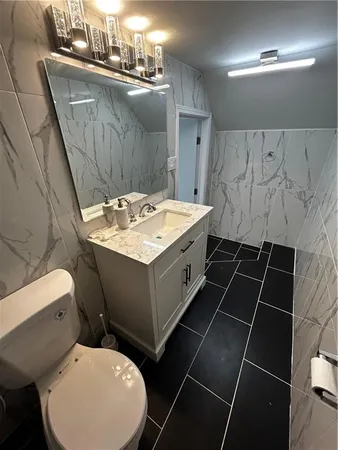 a bathroom with a toilet sink and mirror