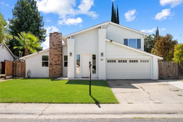 a view of a house with a yard and garage