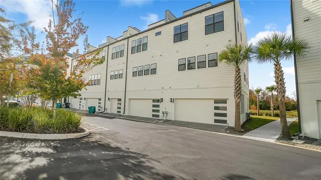a view of a white house with a yard and plants