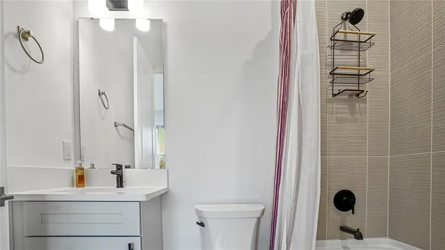 a bathroom with a sink mirror and shower
