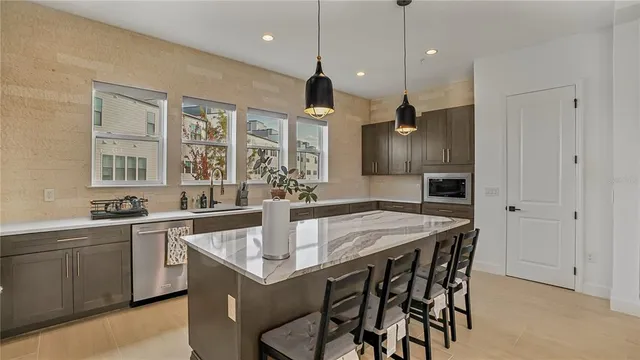 a kitchen with a stove a sink dishwasher a dining table and chairs with wooden floor